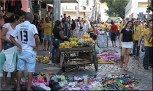 Carros, ônibus, pedestres e camelôs dividem as rua