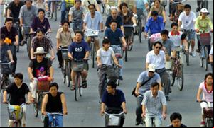Chineses andam de bicicleta em avenida de Pequim