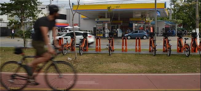 Ciclista observa bikes públicas em avenida de São