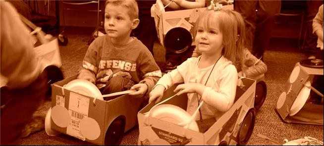 Crianças brincam de carrinhos-caixas em escola