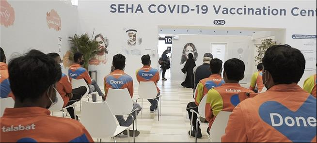 Entregadores de app em sala de vacinação nos Emira