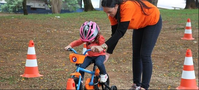 Monitores ensinam crianças pequenas a pedalar