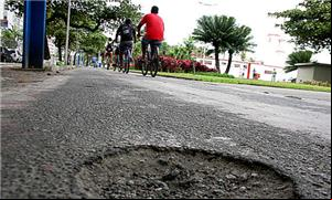 Sequência de buracos obriga ciclista a desviar