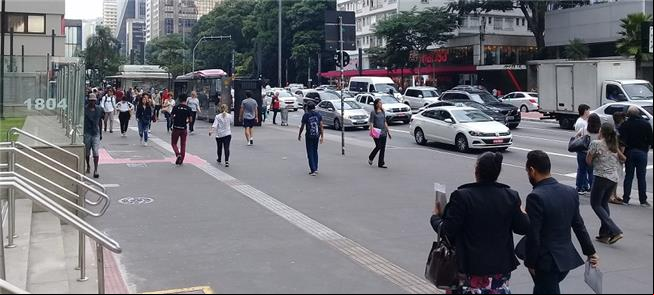 Trabalhadores caminham pela Avenida Paulista, em S
